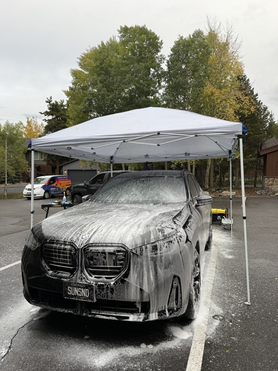 Black BMW SUV covered in snow foam during a Vortan mobile wash and wax