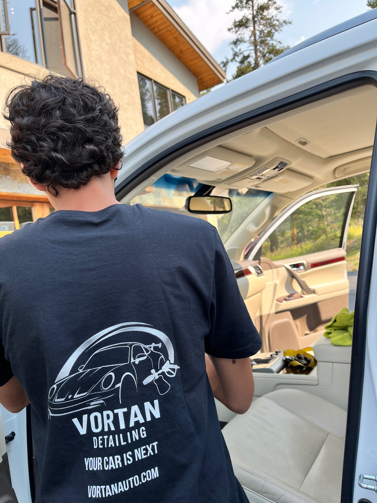 Vortan detailer in branded shirt deep cleaning a Lexus SUV interior in Summit County